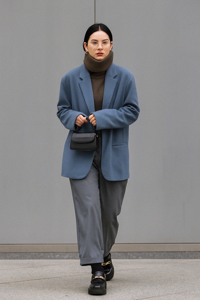 Pantalon flottant : Blazer bleu et mocassins noirs à boucle dorée.