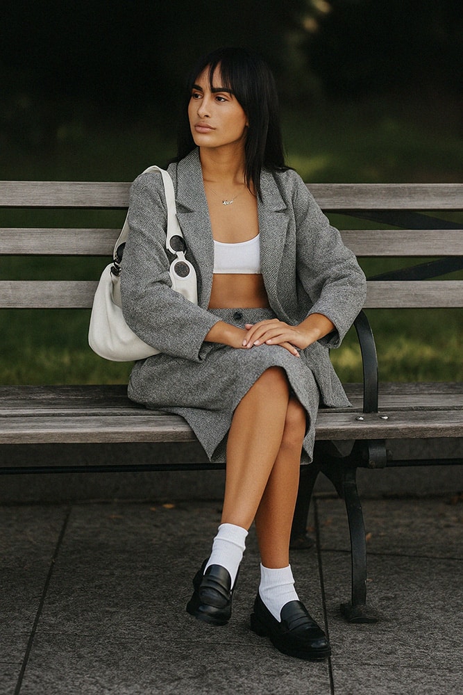 Ensemble gris et top blanc avec mocassins noirs.